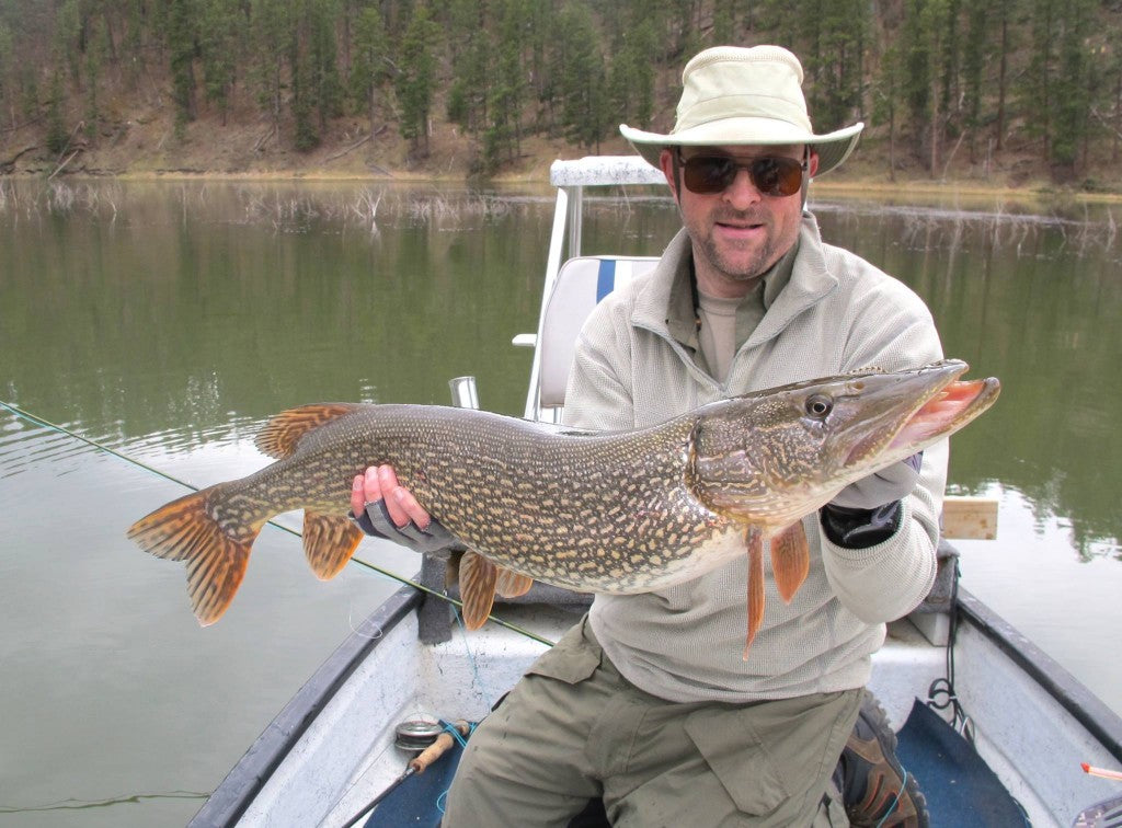 Happy client with a hefty Pike caught on a popper on the surface